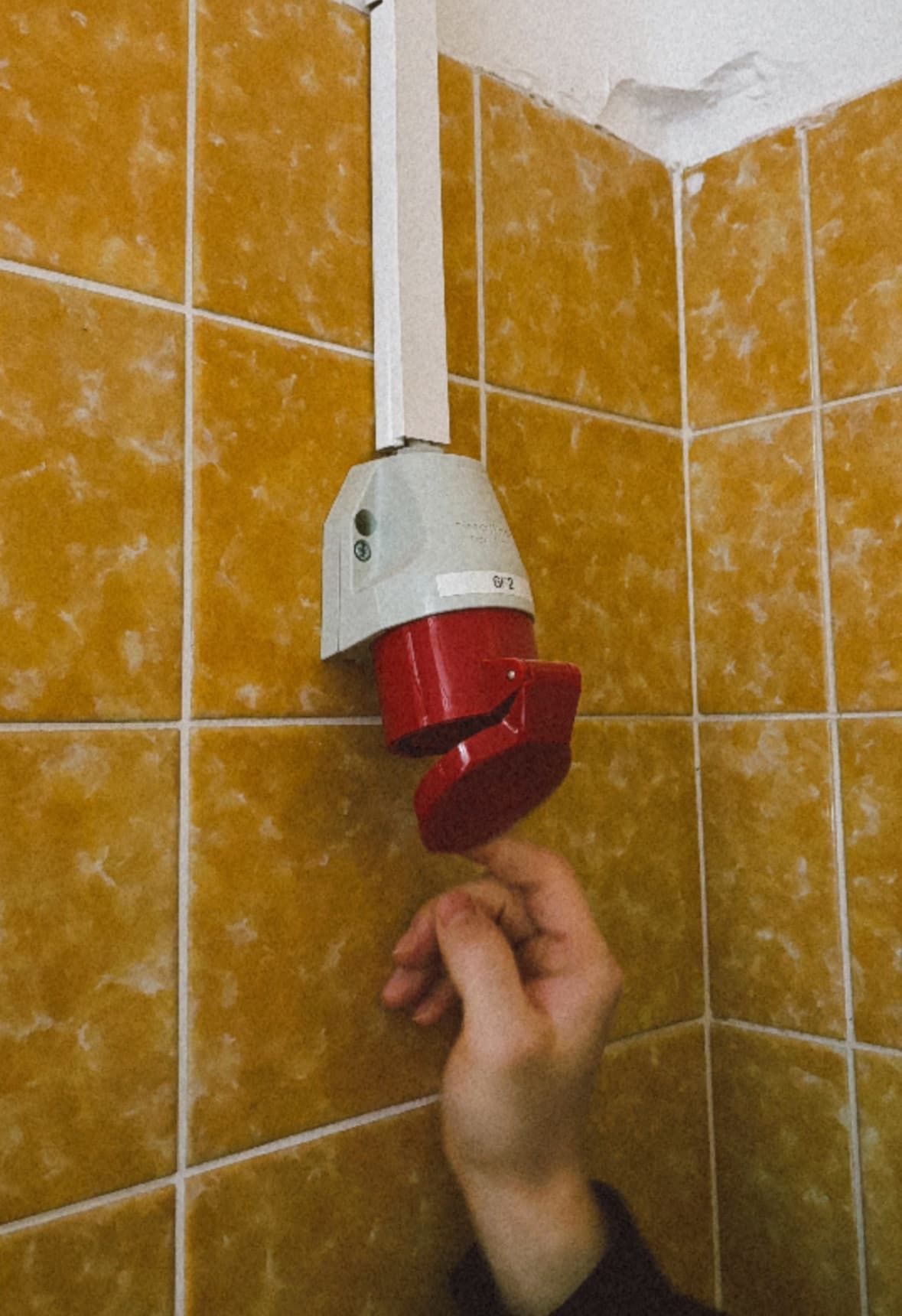 Eine Hand die zärtlich die Abdeckung des Starkstromsteckers öffnet